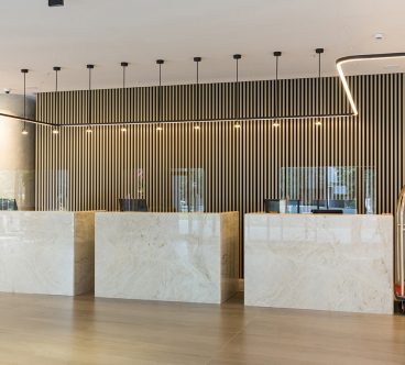 Interior of a hotel lobby with reception desks with transparent coronavirus plexiglass lexan clear sneeze guards