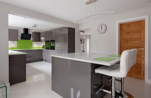 Contemporary fitted kitchen in striking lime green, grey and white colour scheme with built in appliances, white granite counter tops dual ovens island breakfast bar and hob